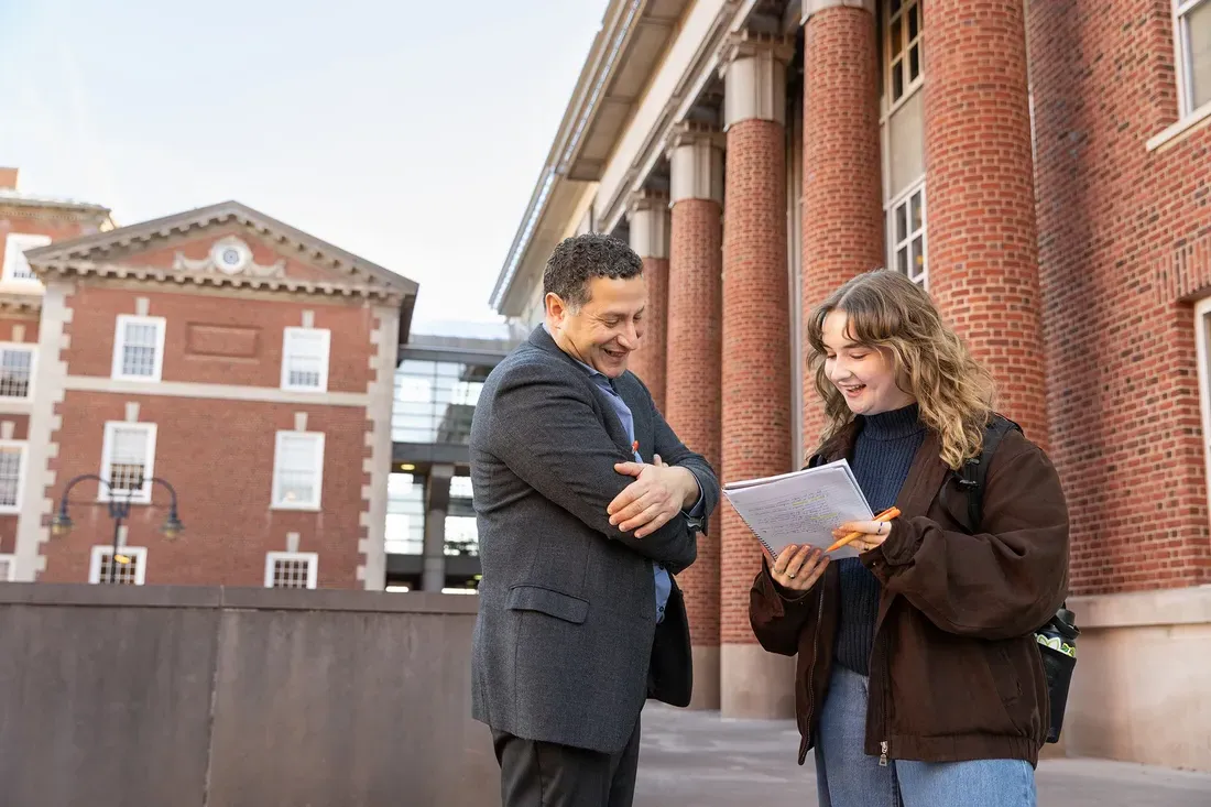 Student and professor talking outside.